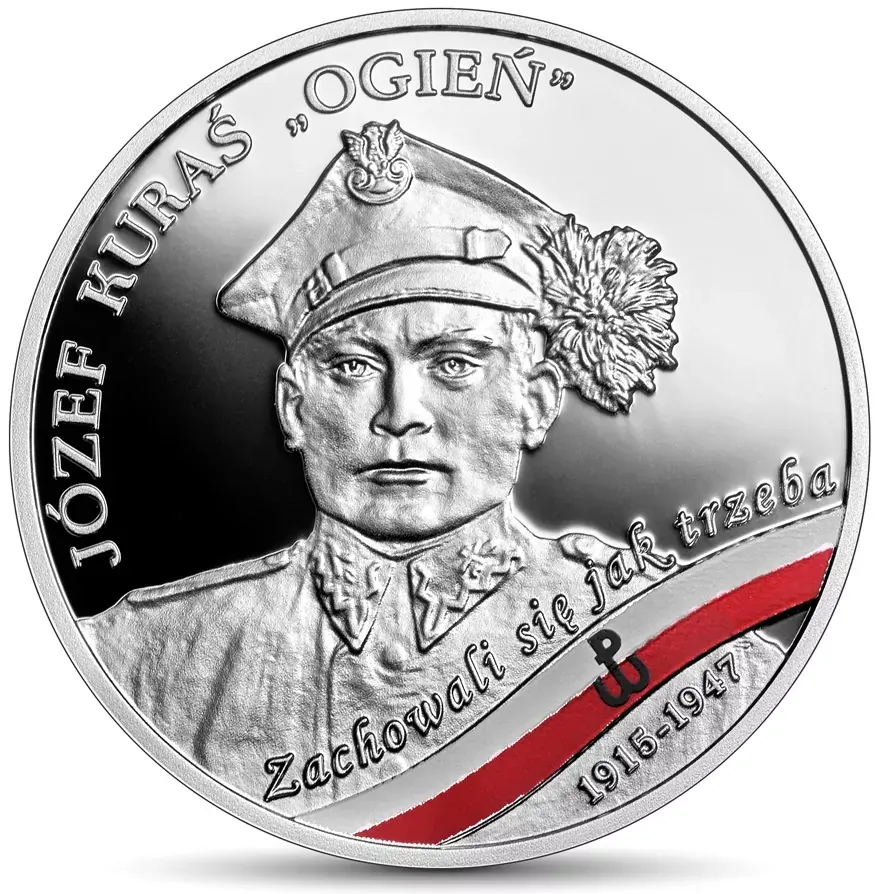 Rewers srebrnej monety NBP z popiersiem Józefa Kurasia w rogatywce z piórem, napisami „Józef Kuraś »Ogień«”, „Zachowali się jak trzeba” i „1915–1947” oraz biało-czerwoną wstęgą ze znakiem Polski Walczącej